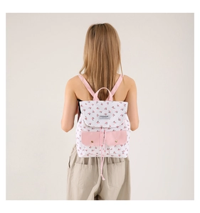 Close-up of floral canvas backpack with pink details and fashion label for students