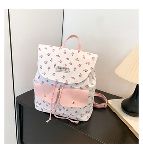 Detail view of large capacity floral backpack with pink straps and fashion label