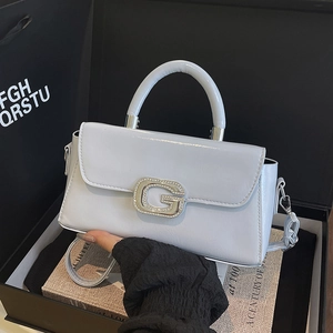 Detail view of light blue glossy square handbag with crystal-encrusted G buckle
