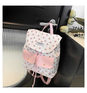 Detail of floral canvas backpack with pink pockets hanging on a modern door handle
