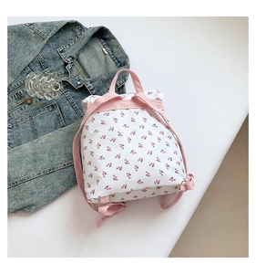 Detail of floral backpack showing pink straps, golden buckles, and cute flower print