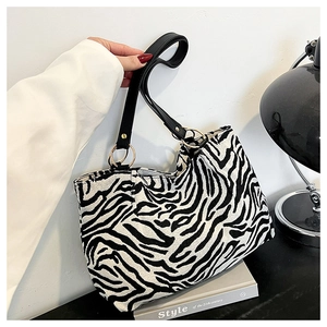Detailed shot of zebra print canvas tote bag with black leather straps and gold metal rings