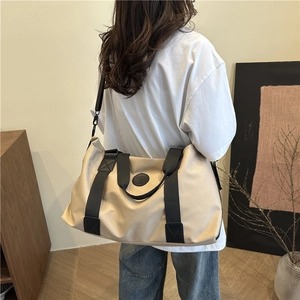 Large beige waterproof canvas travel bag with black straps for gym and weekend trips