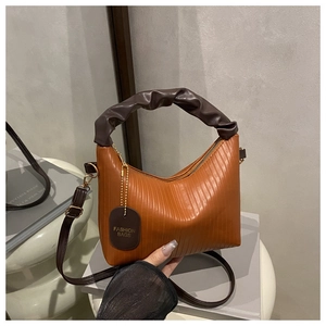 Détail du sac plissé caramel avec texture verticale et poignée nuage marron