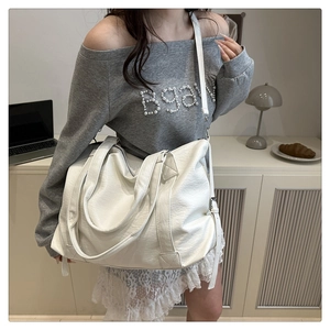 Detailed view of white large capacity tote bag featuring lychee grain PU leather and long strap
