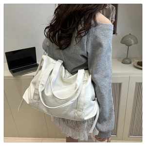 White large capacity leather tote bag with dual handles and shoulder strap shown on model