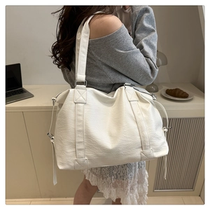 Detail of white large-capacity tote bag featuring textured lychee pattern PU leather