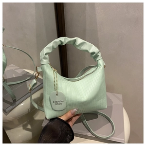 Détail de la poignée froncée vert menthe et texture du cuir gaufré du petit sac carré