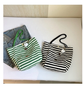 Details gestreifter Canvas-Shopper mit Metallverschluss und Plüsch-Anhänger