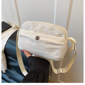 Creamy white nylon crossbody bag with adjustable strap and metal M logo detail
