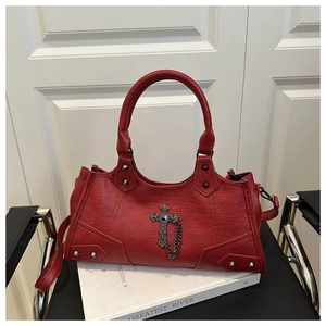 Detailed view of red gothic leather handbag featuring metal cross and rivet decorations