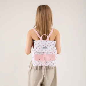 Floral canvas backpack for women with pink trim and drawstring closure in studio view