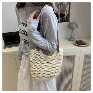 Dettaglio della borsa tote in rete traforata con spallacci in pelle marrone rinforzata