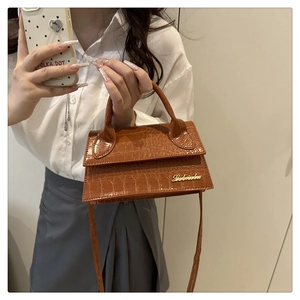 Detailed macro view of dark brown crocodile texture on PU leather crossbody square bag