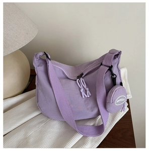 Detail of light purple nylon crescent crossbody bag with mini round coin purse attachment