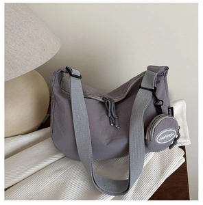 Detail of grey-purple half-moon tote bag with adjustable strap and round coin purse
