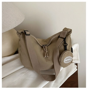 Detail of khaki nylon crescent bag with textured fabric and small round coin purse