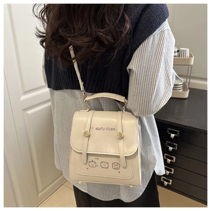 Detail showing back view of cream mini backpack with cartoon print and top handle