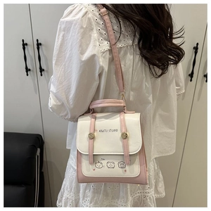 Detail of pink and white PU leather backpack with bear illustration and golden buckle