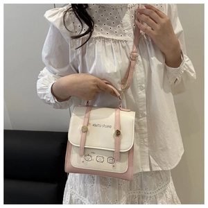 Detail of pink and white crossbody bag with cartoon graphics and adjustable strap