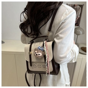 Detail of retro faux leather backpack with plush pendant and color-blocking design