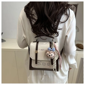 Detail of vintage contrast color backpack with cute plush charm and cartoon bears