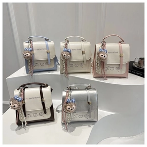 Detail view of stylish color-block PU leather handbags with cute animal prints and charms