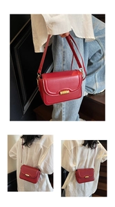 Close-up of vintage red leather crossbody bag with golden metal buckle and leather strap