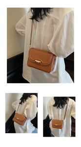 Detail of vintage brown leather crossbody bag featuring a golden triple-ring buckle