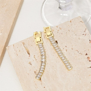 Elegant 18K gold plated long tassel earrings with sparkling crystals on travertine stone