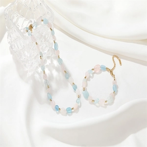 Ensemble collier et bracelet ajustable en pierres de cristal avec détails dorés