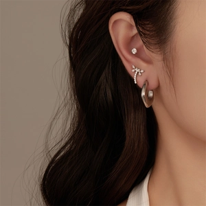 Detail showing G23 titanium silver earrings with dragonfly and rhinestone piercing studs