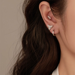 Macro shot of G23 titanium ear piercing set with moth stud and curved zircon bar