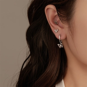 Detail of G23 titanium flat back piercing set with butterfly and leaf zircon studs