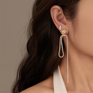 Detailed view of elegant gold stud earrings with long silver snake chain fringe tassels