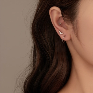 Detail of G23 titanium flat back studs and S925 silver hoop earrings set on ear