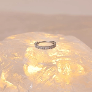 Macro-opname van zilveren F136 titanium scharnierring met dubbele rij zirkonia steentjes