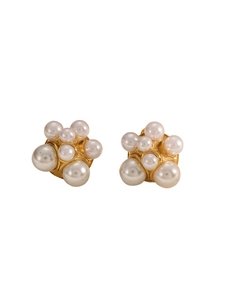 Detailed view of luxury gold floral earrings with cluster of elegant white pearls