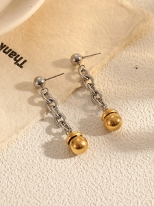 Détail de boucles d'oreilles bicolores avec perles argentées et une grande sphère dorée
