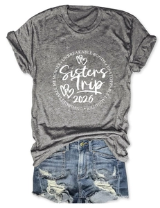 T-shirt gris Sisters Trip 2026 et short en jean déchiré posés à plat sur fond blanc