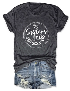 Détail du motif Sisters Trip 2026 sur un t-shirt gris anthracite et un short en jean bleu