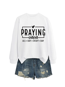 Détail de l'imprimé Praying Mama et du motif coeur sur un sweat-shirt blanc à manches longues