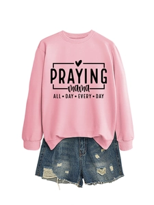 Détail du sweat rose avec imprimé Praying Mama et mini short en jean bleu délavé