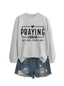 Gros plan sur l'imprimé Praying Mama du sweat gris avec un short en jean bleu délavé