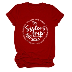 Gros plan sur l'imprimé blanc Sisters Trip 2026 sur le tissu en coton du t-shirt rouge