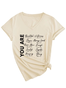 Détail d'un t-shirt crème à col en V avec texte inspirant et nœud à l'ourlet