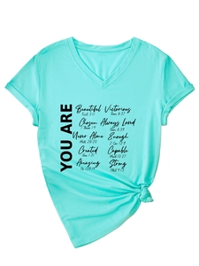 Détail du t-shirt vert menthe à col en V avec texte inspirant et nœud élégant à l'ourlet