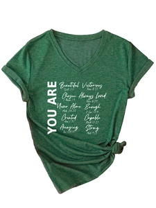 Détail du t-shirt vert à col en V avec imprimé inspirant et ourlet noué élégant