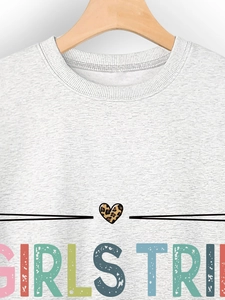 Detail of grey crewneck sweatshirt featuring a colorful Girls Trip print and leopard heart