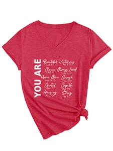 Détail du T-shirt rouge à col en V avec imprimé You Are et nœud décoratif sur le côté